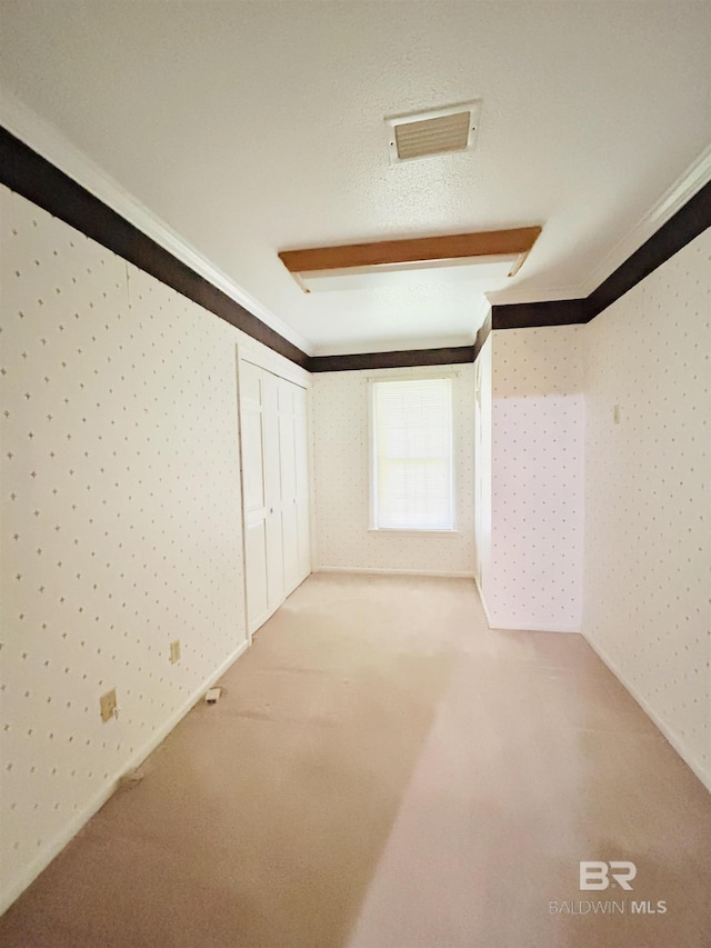 interior space featuring visible vents, carpet flooring, wallpapered walls, and ornamental molding