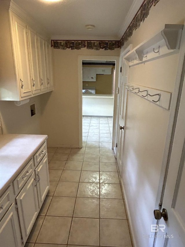 interior space featuring washer hookup, light tile patterned floors, and cabinet space