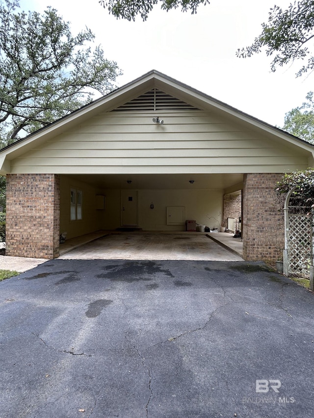 exterior space featuring aphalt driveway and a carport