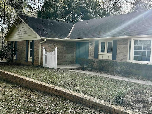 single story home featuring brick siding