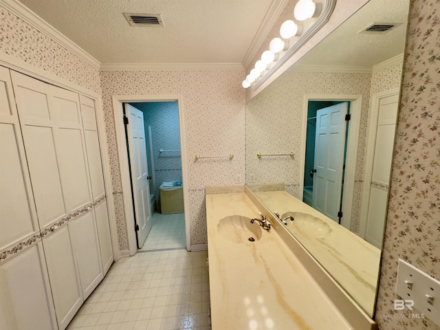 bathroom featuring wallpapered walls, crown molding, visible vents, and a textured ceiling