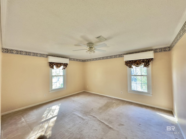 spare room featuring visible vents, ceiling fan, a textured ceiling, and baseboards