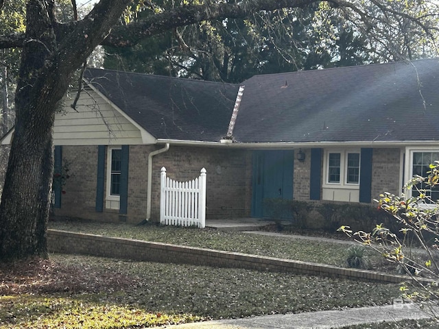 ranch-style house featuring brick siding and fence