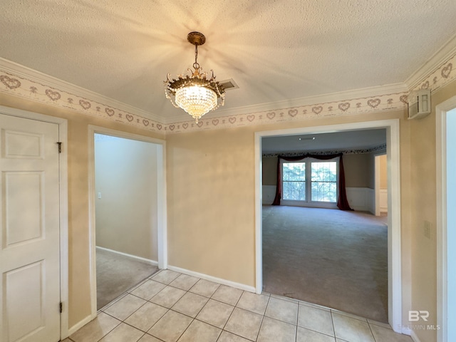 empty room with light colored carpet, ornamental molding, light tile patterned floors, a notable chandelier, and a textured ceiling