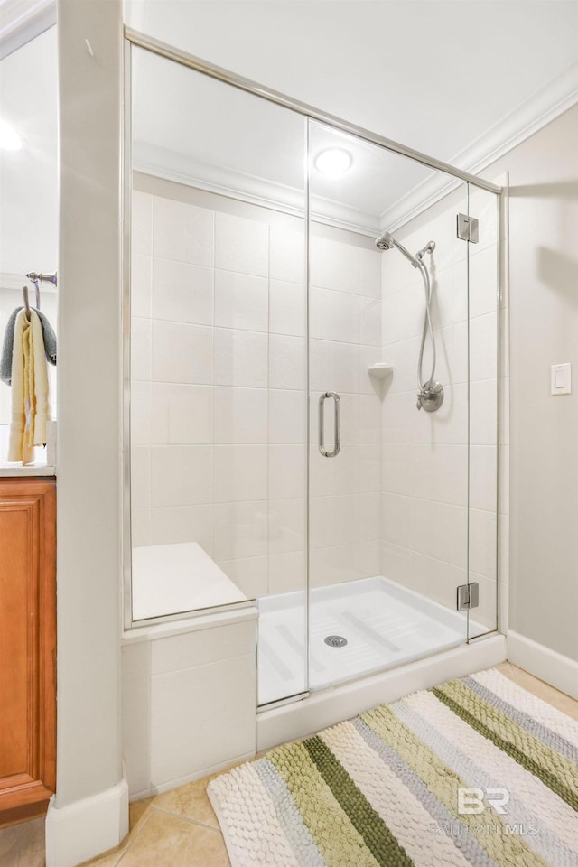 bathroom featuring ornamental molding, a shower stall, and tile patterned floors