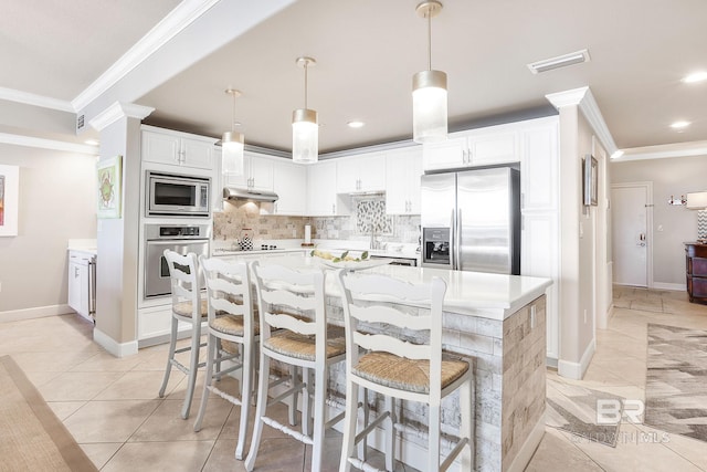 kitchen with appliances with stainless steel finishes, a center island, white cabinets, and hanging light fixtures