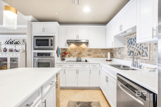 kitchen featuring pendant lighting, stainless steel appliances, a sink, and light countertops