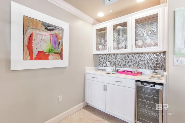 bar with light tile patterned floors, beverage cooler, a sink, wet bar, and tasteful backsplash