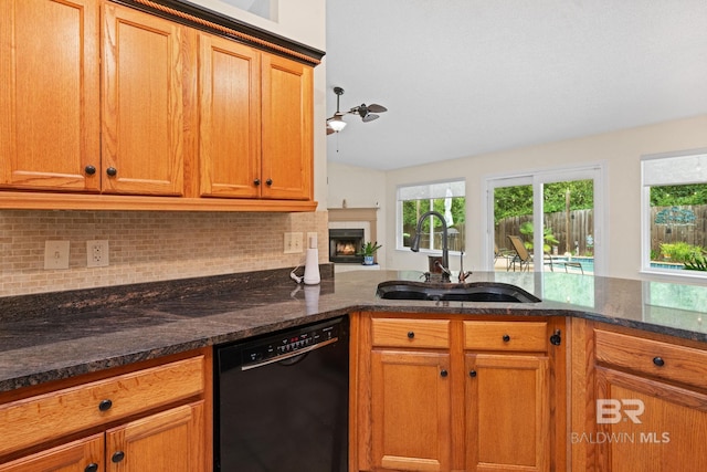 25391 Monarch Ct, Loxley, AL 36551 - kitchen featuring dishwasher, a sink, tasteful backsplash, dark stone countertops, and brown cabinetry