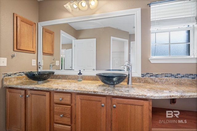 25391 Monarch Ct, Loxley, AL 36551 - bathroom with double vanity and tasteful backsplash