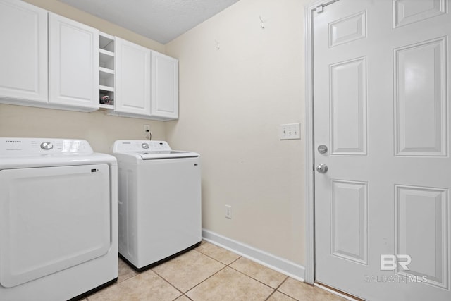 25391 Monarch Ct, Loxley, AL 36551 - laundry room with cabinet space, washing machine and clothes dryer, baseboards, and light tile patterned flooring