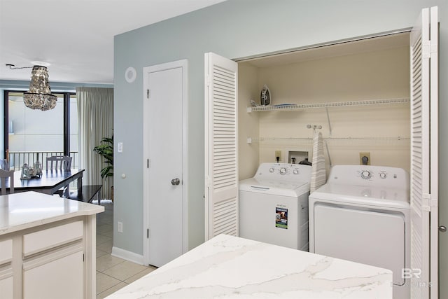 24900 Perdido Beach Blvd Unit 1506, Orange Beach, AL 36561 - washroom featuring light tile patterned floors, a notable chandelier, and washing machine and clothes dryer