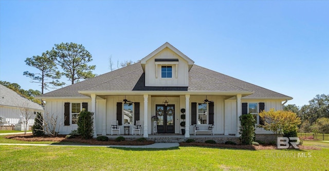 view of front facade with ceiling fan, a front lawn, board and batten siding, french doors, and a porch