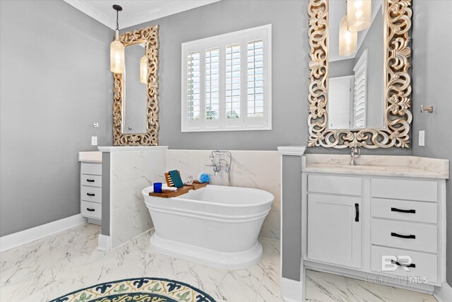 full bathroom with marble finish floor, crown molding, a freestanding tub, and vanity