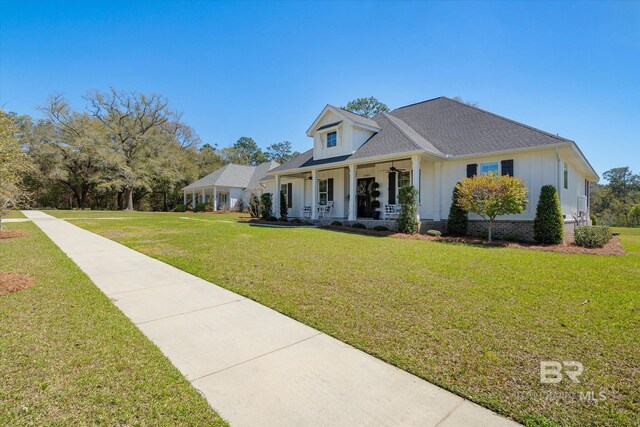 view of front of home with a front lawn, a porch, board and batten siding, and roof with shingles