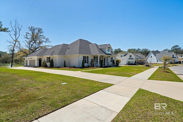 view of front of house featuring a front lawn, a residential view, driveway, and an attached garage