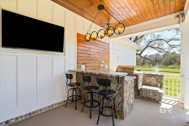 exterior space with a decorative wall, wood ceiling, decorative light fixtures, and finished concrete floors