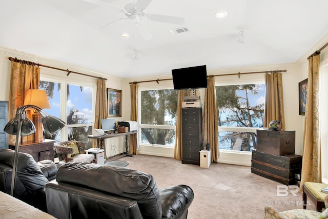 carpeted living area with crown molding, a ceiling fan, and visible vents