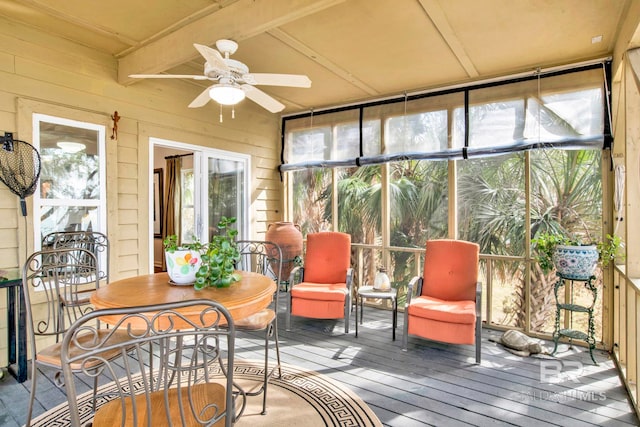 sunroom / solarium featuring beam ceiling and a ceiling fan