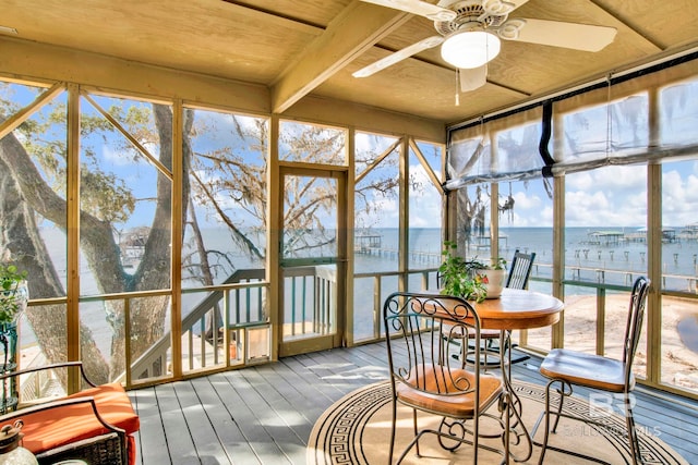 sunroom featuring a water view and ceiling fan