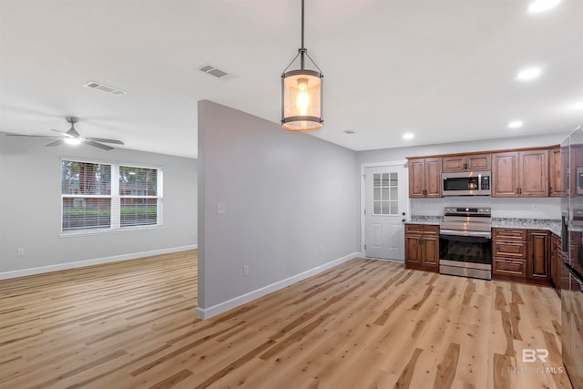 kitchen featuring ceiling fan, decorative light fixtures, light hardwood / wood-style flooring, stainless steel appliances, and light stone countertops