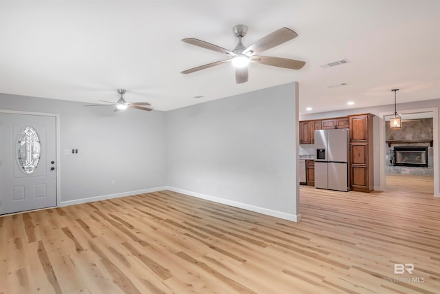 unfurnished living room with light hardwood / wood-style flooring and ceiling fan