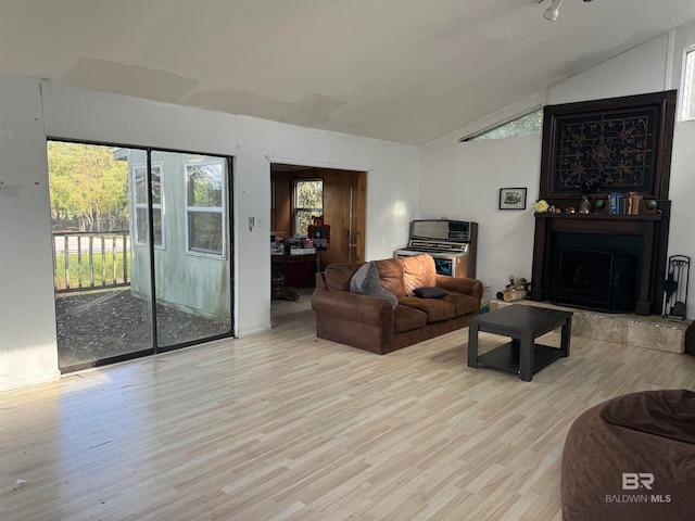 living room featuring light hardwood / wood-style floors and vaulted ceiling