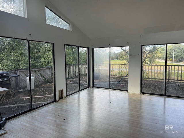 unfurnished sunroom featuring a healthy amount of sunlight and lofted ceiling