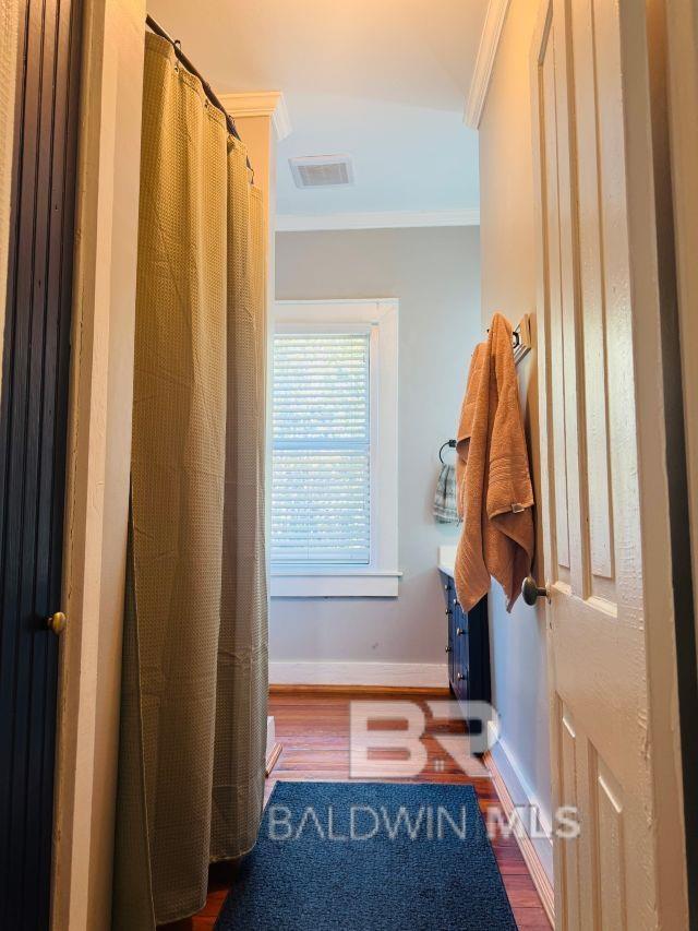 54 S Catherine St, Mobile, AL 36604 - full bathroom with crown molding, wood finished floors, baseboards, and curtained shower