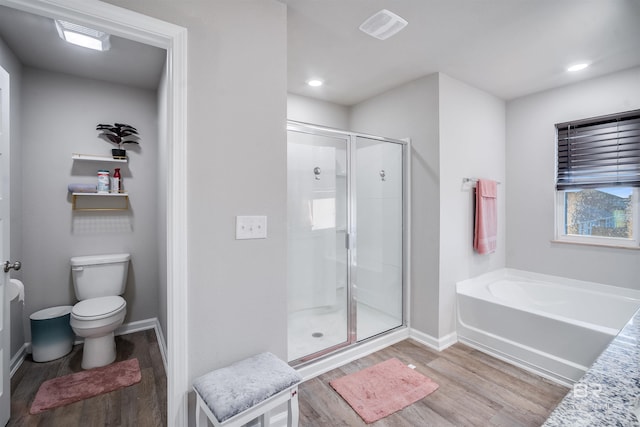 bathroom with toilet, plus walk in shower, and hardwood / wood-style flooring