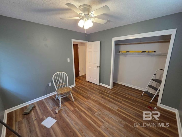 bedroom with a textured ceiling, wood finished floors, baseboards, a closet, and ceiling fan