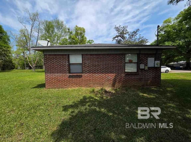 view of home's exterior featuring brick siding and a lawn
