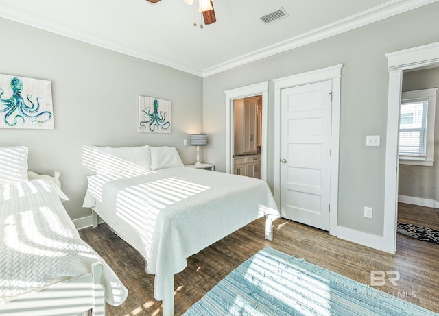 bedroom with baseboards, visible vents, wood finished floors, and ornamental molding