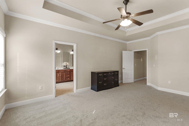 unfurnished bedroom featuring light carpet, crown molding, a raised ceiling, and ensuite bathroom