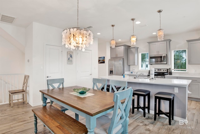 dining room featuring light wood-type flooring and a chandelier