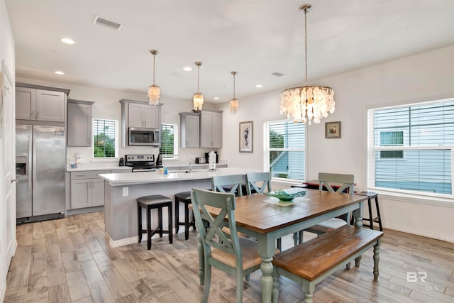 dining room featuring light hardwood / wood-style flooring, an inviting chandelier, and sink