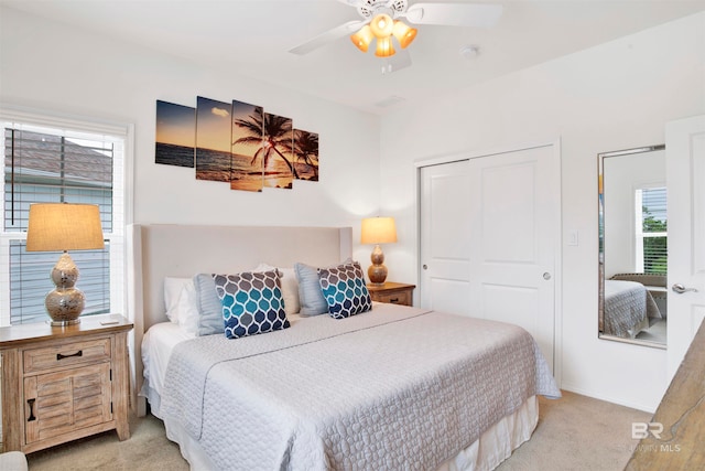 carpeted bedroom featuring multiple windows, ceiling fan, and a closet