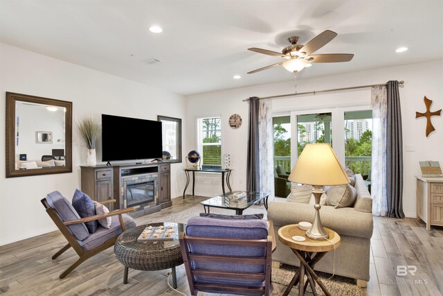 living room featuring ceiling fan and light hardwood / wood-style floors