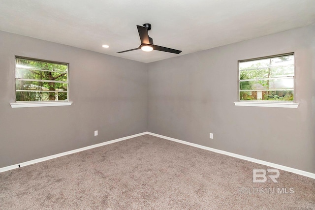 carpeted spare room with ceiling fan