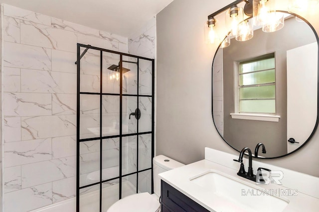 bathroom featuring a shower with door, vanity, and toilet