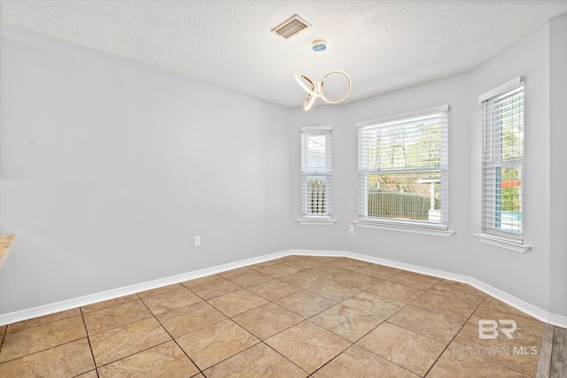 26715 Terry Cove Dr, Orange Beach, AL 36561 - empty room featuring light tile patterned flooring, a textured ceiling, and baseboards