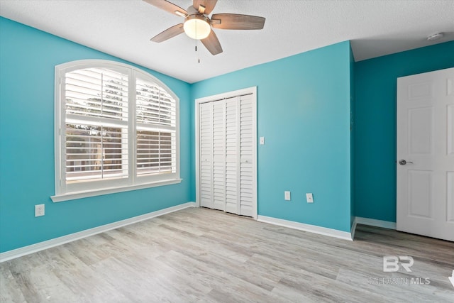 26715 Terry Cove Dr, Orange Beach, AL 36561 - unfurnished bedroom with wood finished floors, baseboards, a closet, ceiling fan, and a textured ceiling