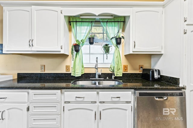 kitchen featuring dishwasher, white cabinetry, dark stone counters, and sink