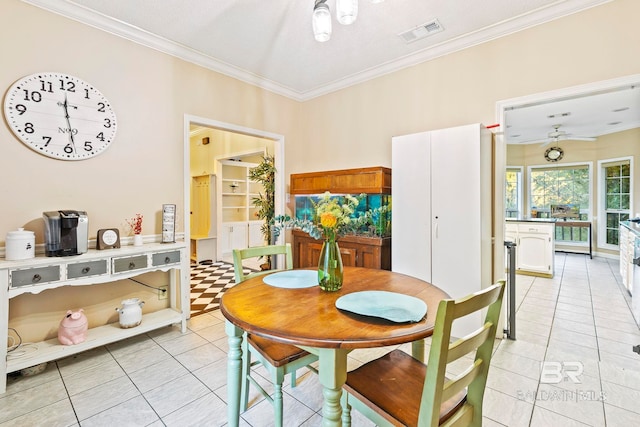 tiled dining space with ceiling fan and ornamental molding