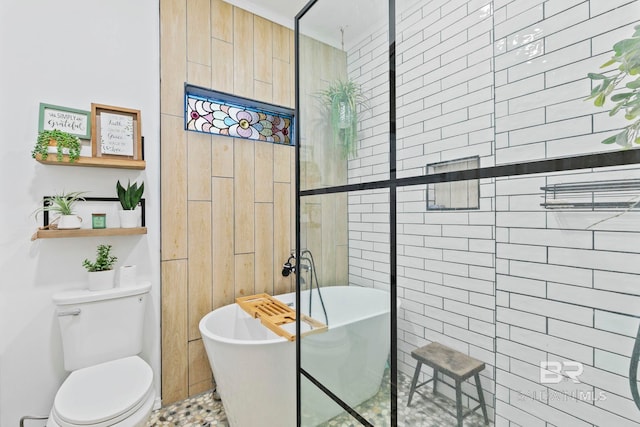 bathroom with a tub to relax in and toilet