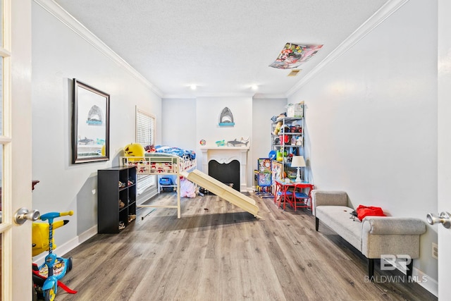 game room featuring hardwood / wood-style floors, a textured ceiling, and ornamental molding