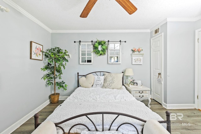 bedroom with ceiling fan, dark hardwood / wood-style floors, ornamental molding, and a textured ceiling