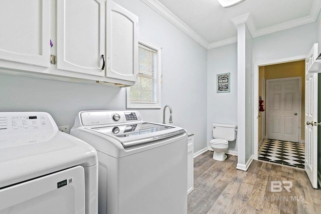 clothes washing area featuring washer and dryer, light wood-type flooring, and ornamental molding