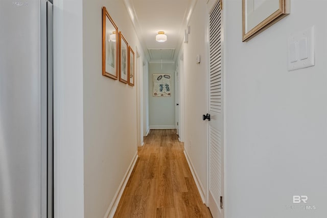 corridor with crown molding and light hardwood / wood-style flooring