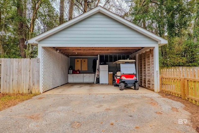 garage with a carport and white fridge